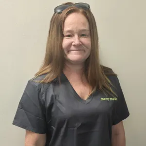 merry maid smiling in front of a tan wall